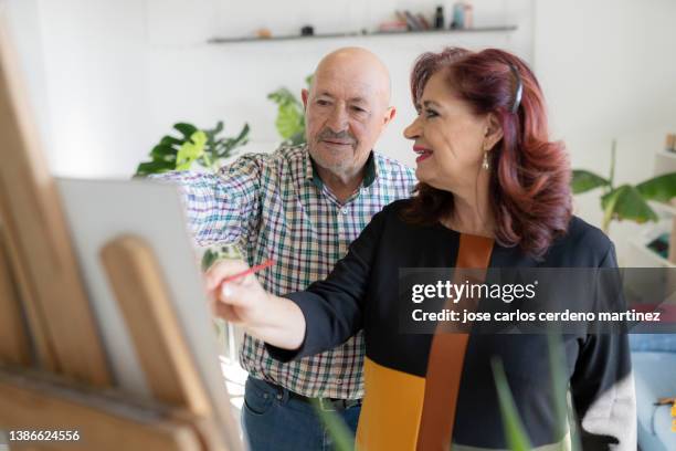 senior mature couple paint a picture at home happy leisure and free time - romanticism art stock pictures, royalty-free photos & images
