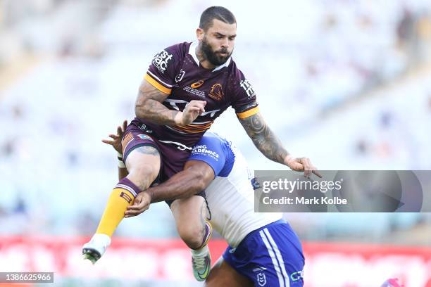 Adam Reynolds of the Broncos is tackled in the air after a kick by Tevita Pangai Junior of the Bulldogs during the round two NRL match between the...