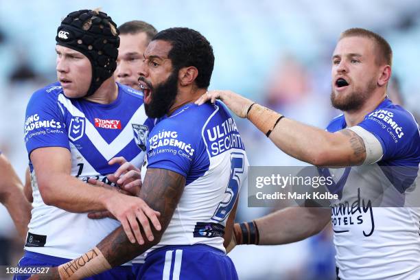 Matt Burton, Josh Addo-Carr and Matt Dufty of the Bulldogs celebrate a defensive effort during the round two NRL match between the Canterbury...