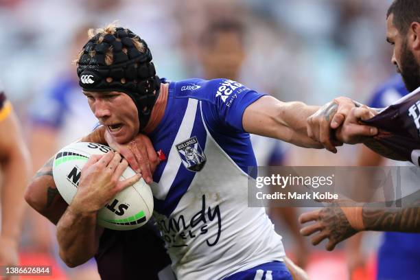 Matt Burton of the Bulldogs is tackled during the round two NRL match between the Canterbury Bulldogs and the Brisbane Broncos at Accor Stadium, on...