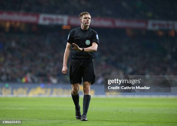 Referee Robert Schroeder looks at the grand stand, after a cup was thrown towards the pitch during the Second Bundesliga match between SV Werder...