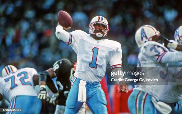 Quarterback Warren Moon of the Houston Oilers passes against the Cleveland Browns as running back Gary Brown and offensive lineman Brad Hopkins block...