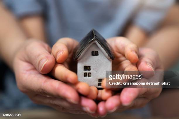 home concept,people, family and home concept - close up of woman and boy holding model house - show home stock pictures, royalty-free photos & images