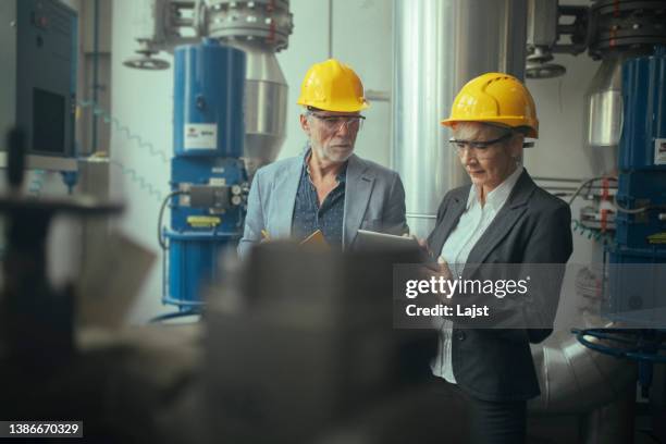umweltingenieure überprüfen den betrieb des heizwerks. - heizöl stock-fotos und bilder