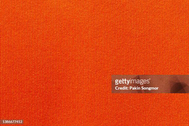 fabric for sports clothing in an orange color, the texture of a football shirt jersey, and a textile background - polyester stock pictures, royalty-free photos & images