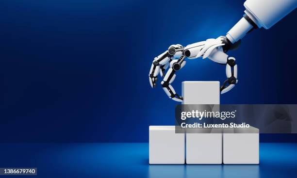 robotics hand grabbing and putting blank white cubic blocks on blue background. innovative industrial technology and artificial intelligence concept. 3d illustration rendering - gripping stock pictures, royalty-free photos & images