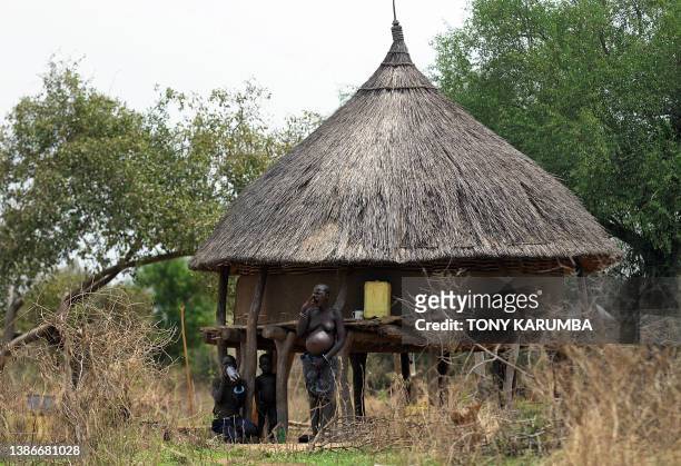 South Sudanese pregnant mother with her children waits at their homestead on April 2 at Terekeka, 82 km north of Juba, an area where the population...