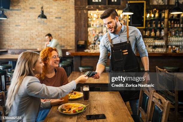 contactless payment for meal in restaurant - small group of people stock pictures, royalty-free photos & images