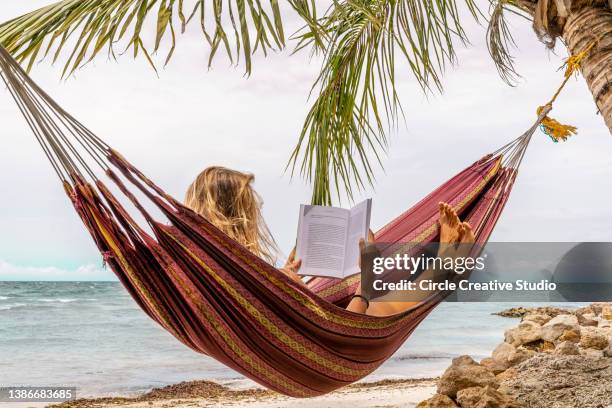 happy woman relaxing in hammock - hammock imagens e fotografias de stock