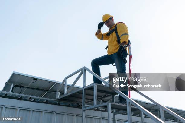 a young mechanic climbs the ladder in the inspection industry. - sicherheitsausrüstung stock-fotos und bilder