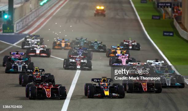 Charles Leclerc of Monaco driving the Ferrari F1-75 leads Max Verstappen of the Netherlands driving the Oracle Red Bull Racing RB18 and the rest of...