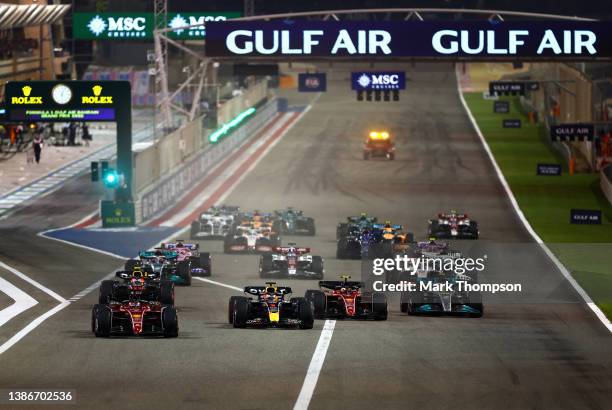 Charles Leclerc of Monaco driving the Ferrari F1-75 leads Max Verstappen of the Netherlands driving the Oracle Red Bull Racing RB18 and the rest of...