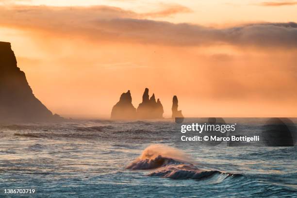 scenic seascape with sea stacks at sunset, iceland - felsformation stock-fotos und bilder