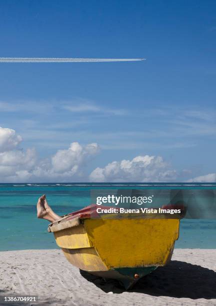 airplane over a woman relaxing in a boat on a beach - punta cana stock pictures, royalty-free photos & images