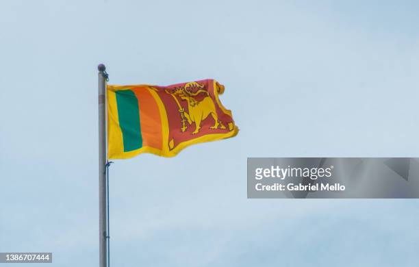 sri lanka flag flying against blue sky - sri lanka flag stock-fotos und bilder