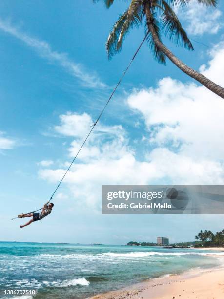 man at dalawella beach swing in sri lanka - rope swing fotografías e imágenes de stock