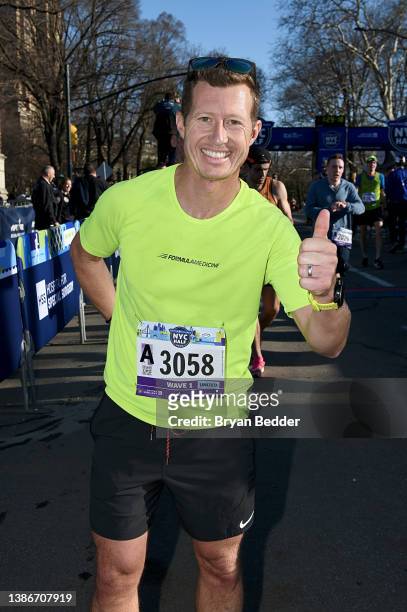 Ryan Briscoe celebrates as he crosses the finish line participates in the 2022 United Airlines NYC Half Marathon on March 20, 2022 in New York City.