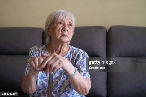 elderly woman with walking stick - fragility stock pictures, royalty-free photos & images