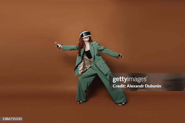 positive smiling woman in virtual reality helmet with copy space uses technology development. happy person in cyberspace wearing 3d vr glasses. device technology concept - computer game controller stock pictures, royalty-free photos & images