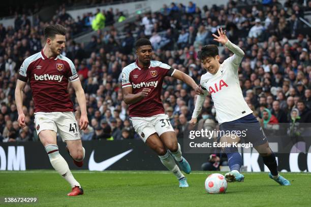 Heung-Min Son of Tottenham Hotspur is challenged by Ben Johnson and Declan Rice of West Ham United during the Premier League match between Tottenham...
