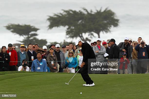 Tiger Woods reacts to a missed putt on the fifth hole as a gallery of fans looks on during the second round of the AT&T Pebble Beach National Pro-Am...