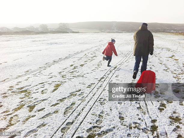 pulling sledde uphill - father and son walking stock pictures, royalty-free photos & images