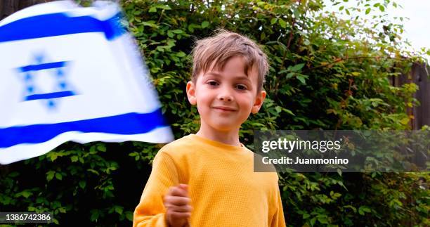 smiling caucasian boy waving a israeli flag looking at the camera - israeli ethnicity bildbanksfoton och bilder