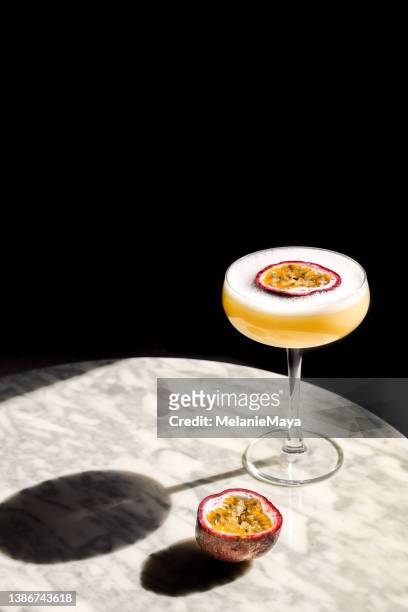 passion fruit cocktail aperitif in coupette glas mit frischem obst und schaum - maracuja stock-fotos und bilder