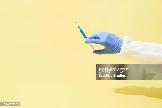 A medical hand holding a syringe pointing up