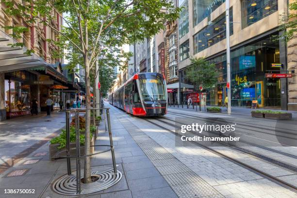 light rail tram traveling in city street, background with copy space - lightrail stock pictures, royalty-free photos & images