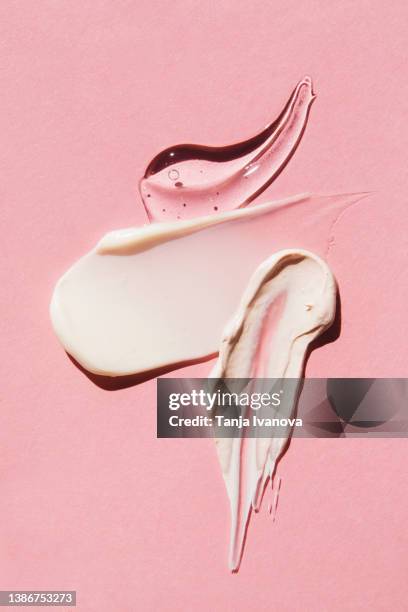 textured multi colored smears of cosmetics on pink background. samples of creams, face mask, face gel, serum. flat lay, top view. - creme textur bildbanksfoton och bilder