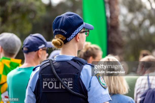 junge polizistin patrouilliert auf der stadtstraße, hintergrund mit kopierraum - australia police stock-fotos und bilder