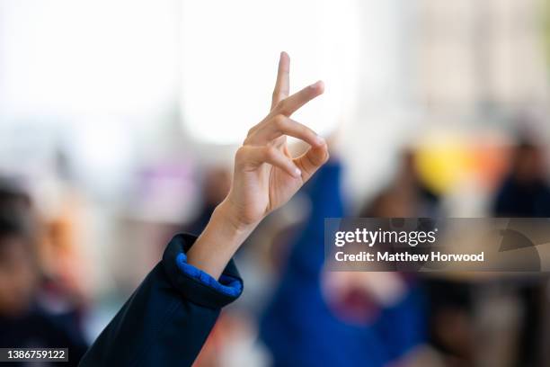 Close-up of a child's hand held in the air in a school classroom on March 14, 2022 in Cardiff, Wales.