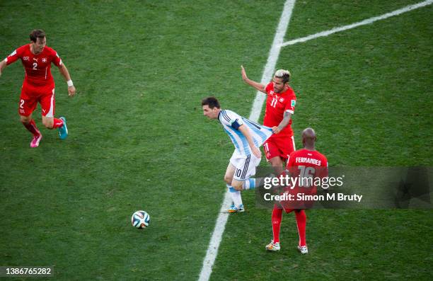 Lionel Messi of Argentina has his shirt pulled by Valon Behrami, with Gelson Fernandes and Stephan Lichtsteiner of Switzerland during World Cup round...
