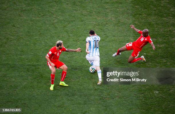 Lionel Messi of Argentina and Valon Behrami and Nelson Fernandes of Switzerland during World Cup round of 16 match between Argentina and Switzerland...