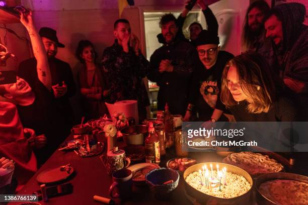 People share dinner and sing happy birthday during a birthday celebration at an artists co-living studio space that has turned into a bomb shelter...