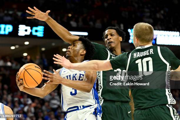 Jeremy Roach of the Duke Blue Devils drives between Marcus Bingham Jr. #30 and Joey Hauser of the Michigan State Spartans in the second half during...