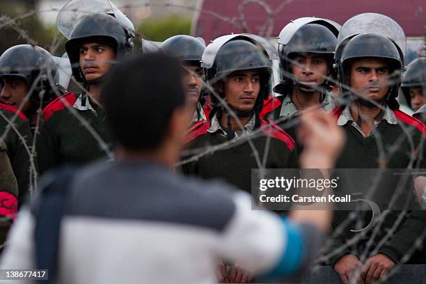 Protester discusses with soldiers behind a barbed wire barrier by the army forces to stop protesters after a demonstration against the military...