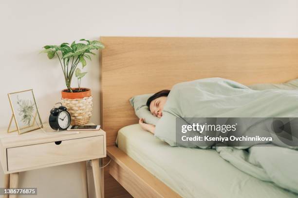 woman sleeping in bed - confort at hotel bedroom ストックフォトと画像