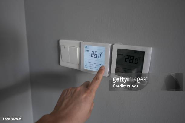 hand pressing the button to turn on the air conditioner - start imagens e fotografias de stock