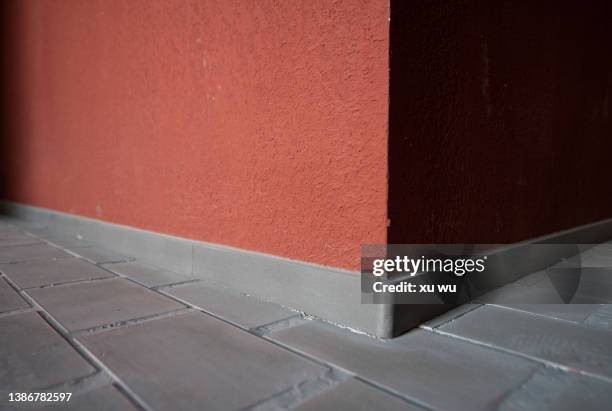the sun shines on the red concrete wall - 角 ストックフォトと画像