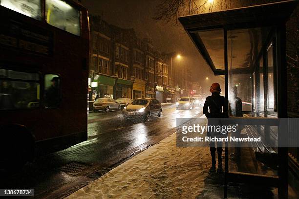 woman waiting for bus - london buses stock-fotos und bilder