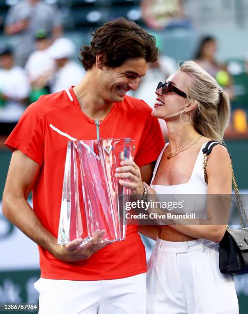 Taylor Fritz of the United States holds his winners trophy with his girlfriend Morgan Riddle after his straight sets victory against Rafael Nadal of...