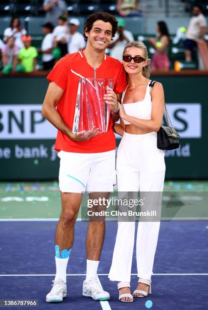 Taylor Fritz of the United States holds his winners trophy with his girlfriend Morgan Riddle after his straight sets victory against Rafael Nadal of...