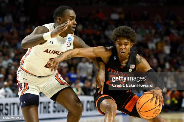 Kameron McGusty of the Miami Hurricanes drives against Jaylin Williams of the Auburn Tigers in the second half during the second round of the 2022...