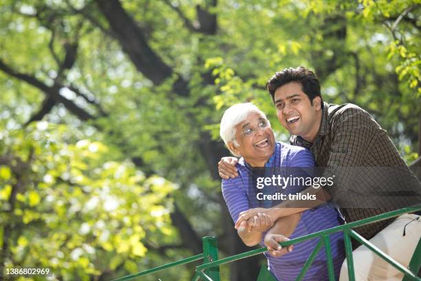 cheerful old man with son having fun at park - indian father stock pictures, royalty-free photos & images