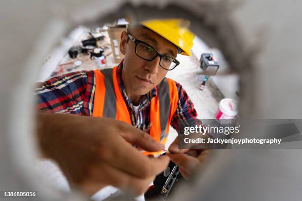 rear view of electrician working at site - wall building feature 個照片及圖片檔