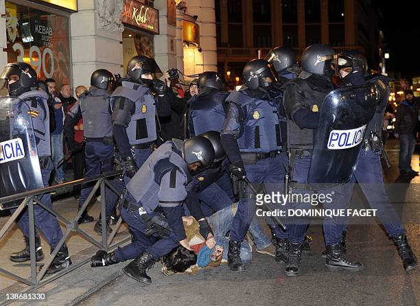 Policemen arrest a protester during clashes following a demonstration organized by Spain's "indignant" protesters at the Puerta del Sol square in...