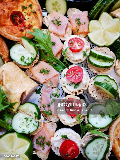 savoury food platter with small canapes decorated with cherry tomatoes and fresh cucumber slices - seafood platter stockfoto's en -beelden