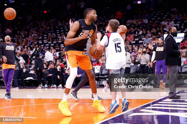 Mikal Bridges of the Phoenix Suns dances with a young fan prior to the game against the Chicago Bulls at Footprint Center on March 18, 2022 in...